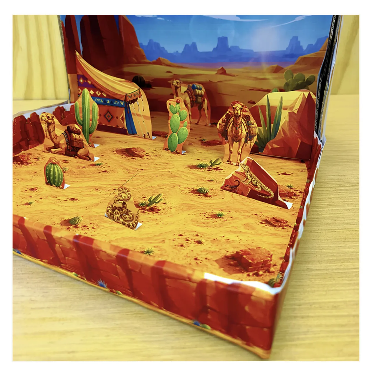 Close view of a 3D desert school project with camels, cacti, tent, snake, rocks and sandy habitat floor