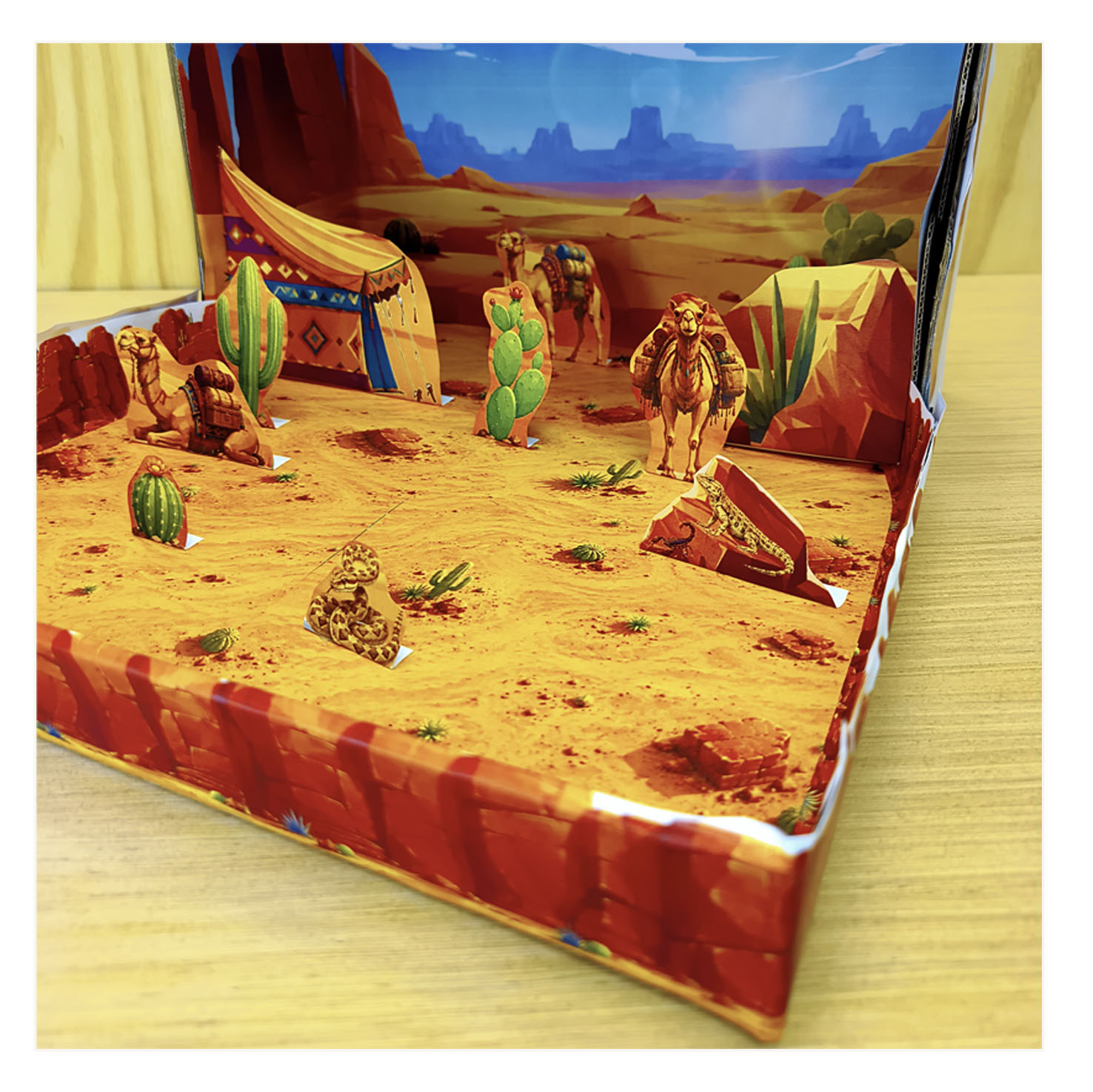 Close view of a 3D desert school project with camels, cacti, tent, snake, rocks and sandy habitat floor