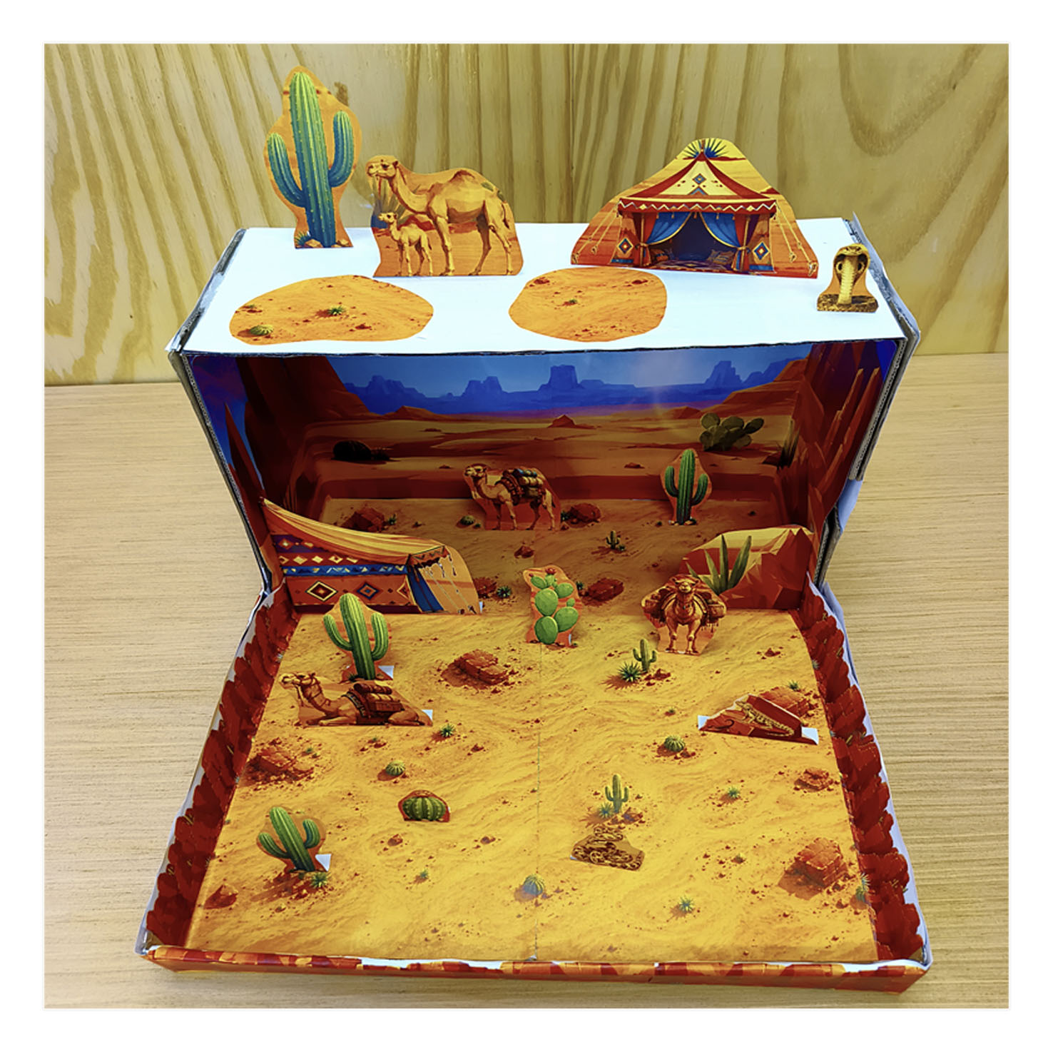 Complete desert habitat diorama model viewed from above and the front with camels, cacti, tent and desert animals