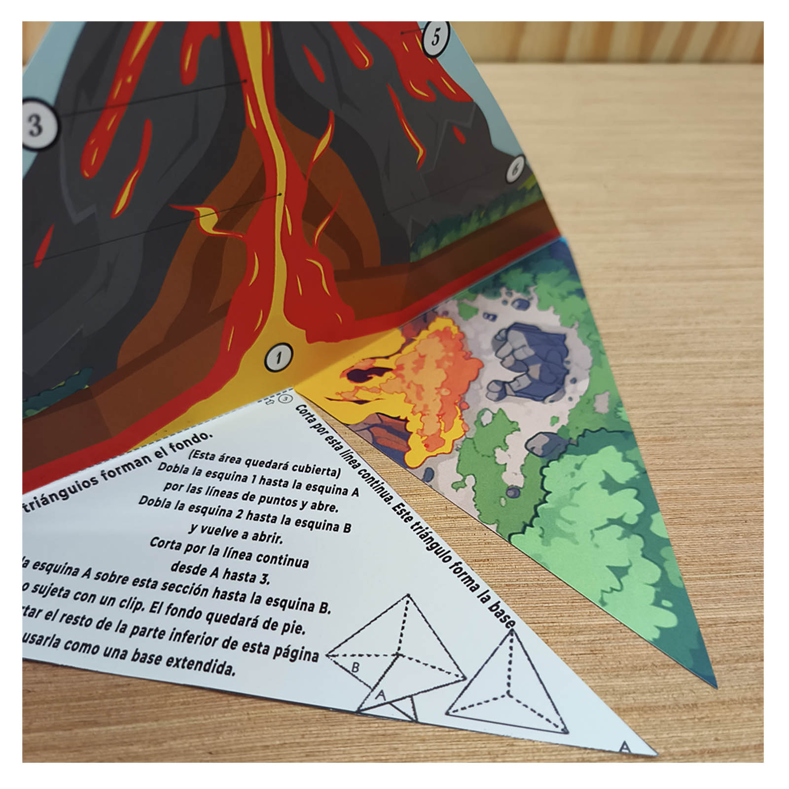 Paper volcano scene with an island, palm trees and an information card explaining how lava creates new land