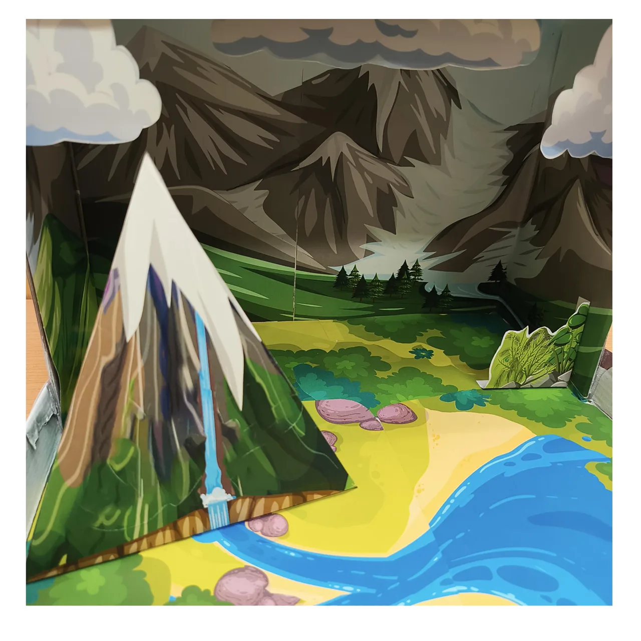Paper mountain positioned beside the river in the shoebox model